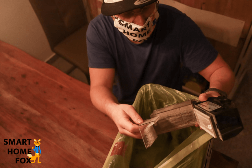 Cleaning the HEPA filter above the dustbin, wearing a face mask.